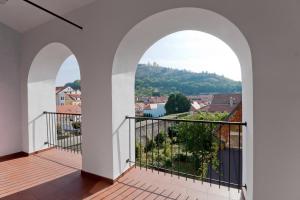 a balcony with two arched windows and a view at Městský penzion Mikulov in Mikulov