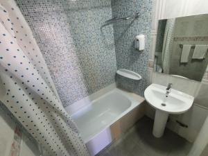 a bathroom with a sink and a tub and a toilet at Plaza Dort Rooms IV in Madrid +23 photos
