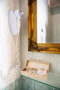 um secador de cabelo na casa de banho com um espelho em Rooms Herman em Pivka