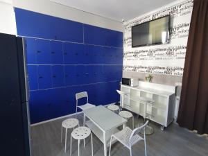 een kamer met een tafel en stoelen en een blauwe muur bij CH Plaza D'Ort Rooms Madrid in Madrid