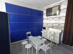 a room with a table and chairs and a blue wall at CH Plaza D'Ort Rooms Madrid in Madrid