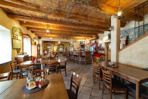ein Restaurant mit Holztischen und -stühlen und einer Bar in der Unterkunft Rooms Herman in Pivka