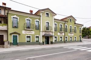 a green building on a city street with a street at Rooms Herman in Pivka