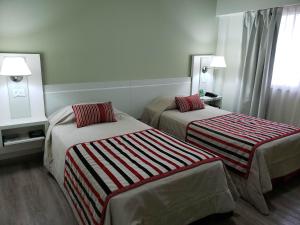 a hotel room with two beds and a window at Hotel Continental in Posadas