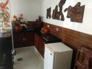 a kitchen with a white refrigerator and a counter top at Hotel Misional in Santa Cruz de la Sierra