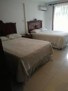 two beds sitting next to each other in a bedroom at Hotel Misional in Santa Cruz de la Sierra