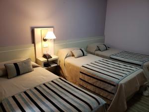 una habitación de hotel con 2 camas y una lámpara en Hotel Continental en Posadas