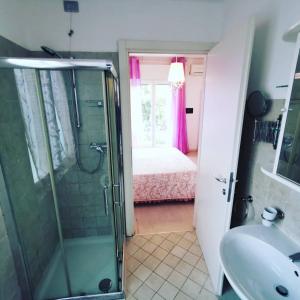 a bathroom with a shower and a sink and a bed at Ai Giardini Rooms in Verona
