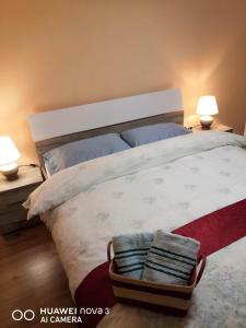 a bedroom with a bed with two lamps and a basket of towels at Cozy central apartment in Cluj Napoca in Cluj-Napoca