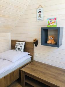 a small bedroom with a bed and a teddy bear at U Wikinga - Domki letniskowe w Mielnie in Mielno