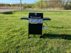 a barbecue grill sitting in the grass in a field at Nites Inn Motel in Cornwall