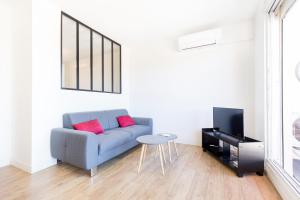 sala de estar con sofá azul y mesa en Appartement Cosy Tout confort - Climatisation, Balcon, WiFi - proche AIRBUS, Purpan, Aéroport, Stade Ernest Wallon, en Toulouse