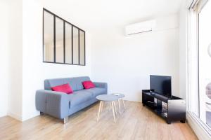 トゥールーズにあるAppartement Cosy Tout confort - Climatisation, Balcon, WiFi - proche AIRBUS, Purpan, Aéroport, Stade Ernest Wallonのリビングルーム(青いソファ、テーブル付)