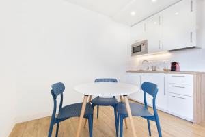 a kitchen with a white table and four chairs at Appartement Cosy Tout confort - Climatisation, Balcon, WiFi - proche AIRBUS, Purpan, Aéroport, Stade Ernest Wallon in Toulouse