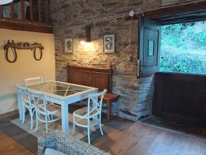 a table and chairs in a room with a stone wall at O Paxar in Samos