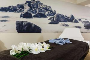 a bed with white flowers on top of it at Best Western Les Bains Hotel et SPA in Perros-Guirec