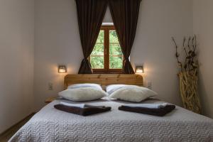 a bed with white sheets and pillows in a room at Rustic Lodge Plitvice in Plitvička Jezera