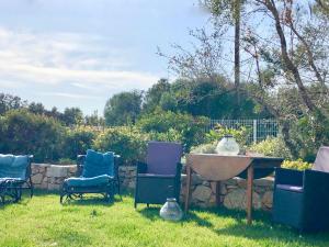 een groep stoelen en een tafel in een tuin bij Les Villas MarInCelu in Porto Pollo