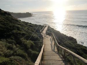 a boardwalk leading to the ocean on a cliff at The Surf Studio - Ericeira in Ericeira