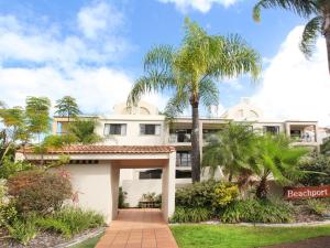 a large white building with palm trees in front of it at 2 bedroom Apt on Parkyn Parade with pool and Airvconditioning in Mooloolaba
