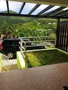 a view of a car parked on a balcony at One bedroom apartement with furnished garden and wifi at La Savane 2 km away from the beach in Happy Bay