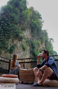 Ein Mann und eine Frau, die auf einer Bank sitzen und trinken in der Unterkunft Xscape Tambun in Ipoh