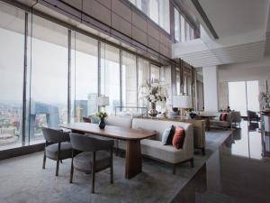 a living room with a couch and tables and windows at Park Hyatt Beijing in Beijing