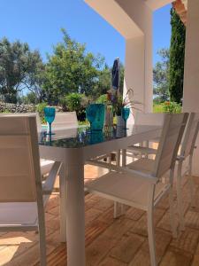 tavolo bianco da pranzo con bicchieri blu di Villa Gwendolin a Portimão