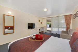 a bedroom with a large bed and a living room at Beechworth Motor Inn in Beechworth