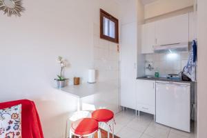 eine Küche mit roten Hockern in einem kleinen Zimmer in der Unterkunft Cozy Apartment Alegria Balcony in Porto