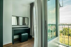 a room with a large window with a view of the city at Winner Sriracha Serviced Apartment in Si Racha