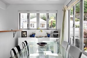 a dining room with a glass table and chairs at TrinketBox in Wellington +2 photos