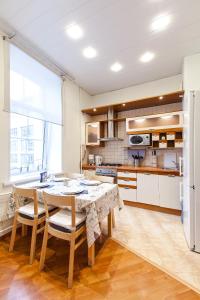 a kitchen with a table and chairs and a refrigerator at Premium Apartment Old Arbat in Moscow