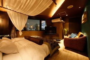 a bedroom with a large bed and a television at Hotel VARKIN in Tokyo