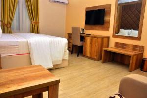 a hotel room with a bed and a desk and a television at Lit Suites in Abuja