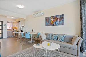 a living room with a couch and tables and a kitchen at Almyrida Panorama view house BY APOKORONAS-VILLAS in Almirida