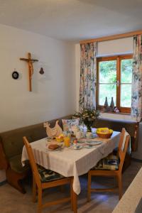 mesa de comedor con una cruz en la pared en Haus Kathrein, en Fliess