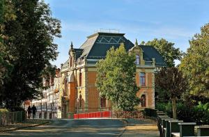 a large brick building with a black roof on a street at Hotel Villa Ponte Wisera in Eschwege