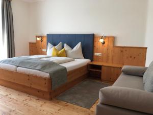 um quarto com uma cama grande e um sofá em Hotel Garni Landhaus Florian em Bad Blumau