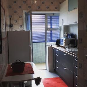 a kitchen with a refrigerator and a table in it at Porta 7 in Canidelo