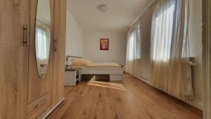 1 dormitorio con 1 cama, 2 ventanas y suelo de madera en Schöne Aussicht, Wallbox, 70qm, kontaktloser Check-in, en Eisenach