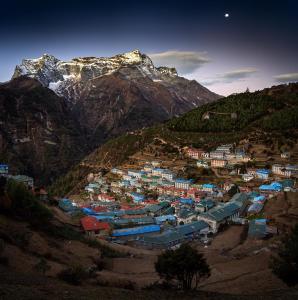 a small town on a hill with a mountain at Panorama Lodge and Restaurant in Nāmche Bāzār