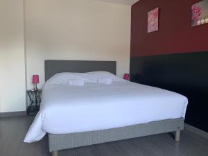 ein Schlafzimmer mit einem weißen Bett und einer roten Wand in der Unterkunft Villa Catalina in Annecy