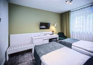 een hotelkamer met 2 bedden en een bureau bij Piccolo Panzió Vendéglő Vinoteca in Zalaegerszeg