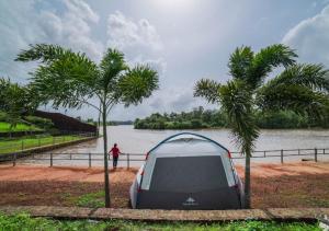 a tent sitting next to a body of water at Campistaan Karjat in Karjat