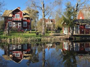 un grupo de casas sentadas junto a un cuerpo de agua en Lottas stuga, en Smedjebacken