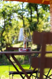 una lámpara de cristal sentada sobre una mesa en un patio en Les Barras’k, en Saint-Péray