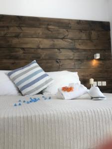 uma cama com almofadas brancas e mirtilos em Ammos Luxury Studios em Aliki