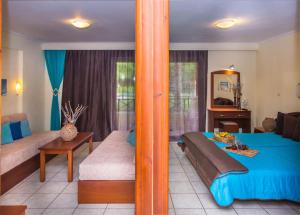 a bedroom with a blue bed and a living room at DAMIA HOTEL Apts in Sidari