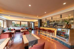 restauracja ze stołami i krzesłami oraz bar w obiekcie Alpenhof Lodge w mieście Saltusio